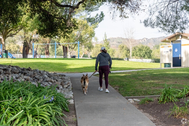 A woman takes her dog for a walk through Del Valle Park in Castaic.