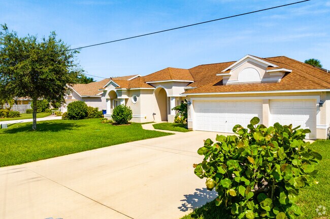 A row of single-family homes in South Beach with terracotta roofs.