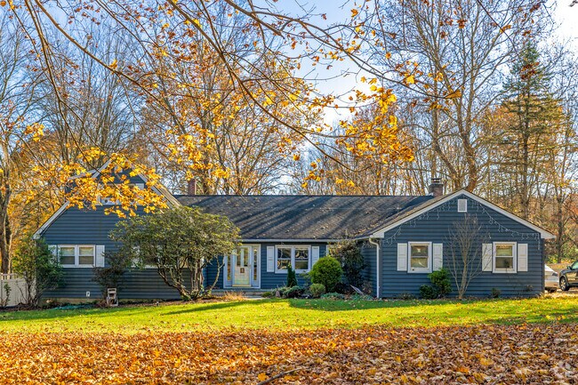 A colorful ranch style home in Mendham is surrounded by fall leaves.
