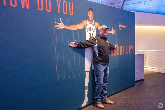 A visitor checks his wing span compared to a NBA player at The Basketball Hall of Fame.