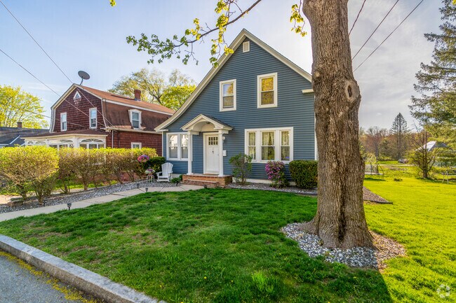 A saltbox style home has a medium sized yard in Winchendon.
