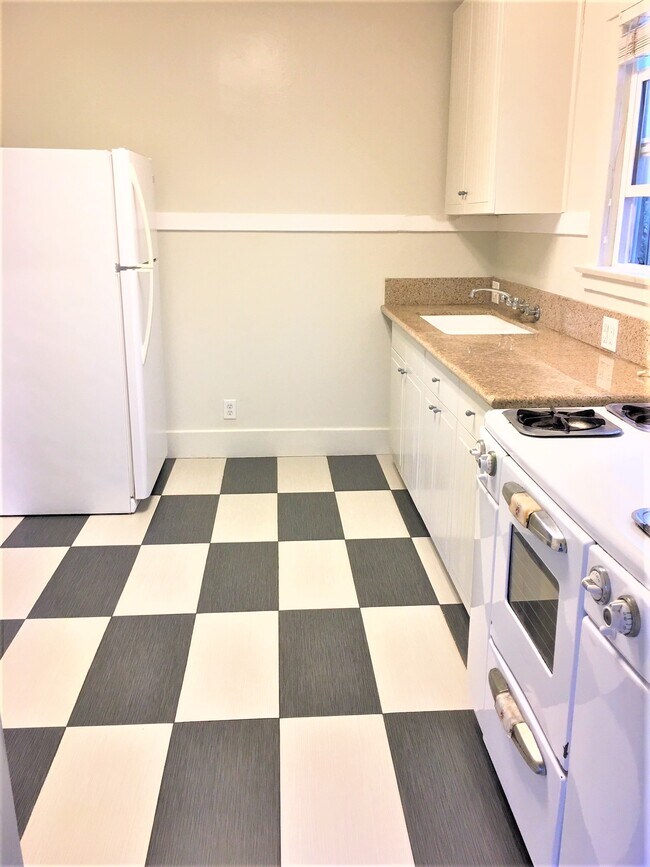 Kitchen granite countertop and tiled floor, refrigerator and stove