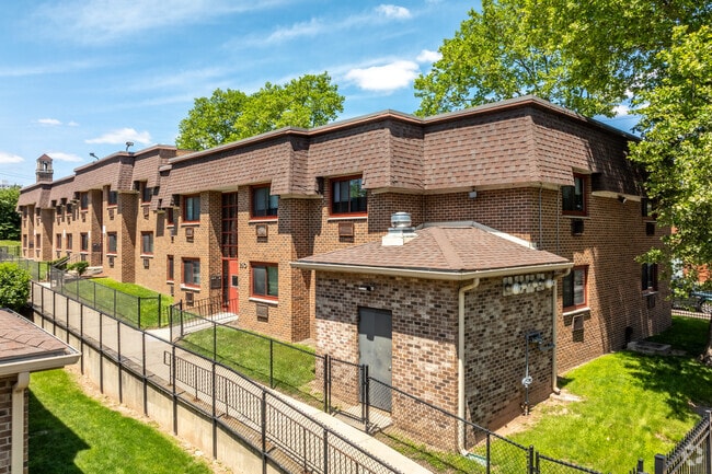 Brick apartment buildings with manicured lawns sit quietly in University Heights.