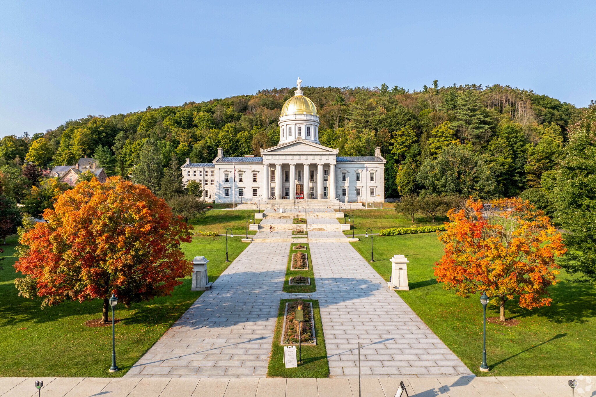 The Vermont Capitol in Downtown Montpelier is framed between two trees in peak foliage.