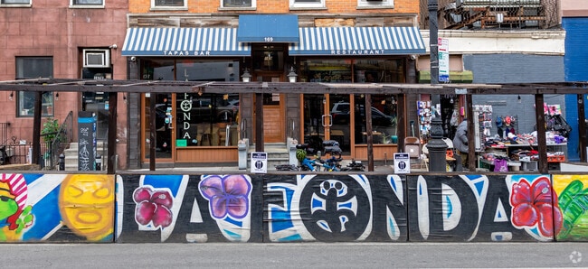 La Fonda exterior has a mini mural displaying its artistic style  with a unique font.