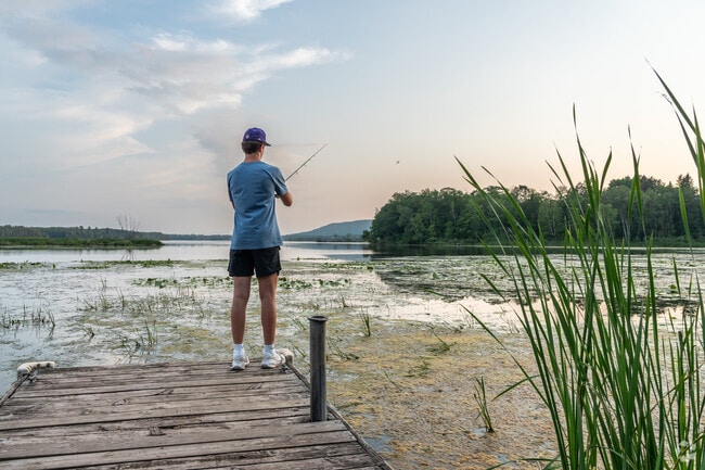 A young man casts his fishing rod into the water along Irving's shores.