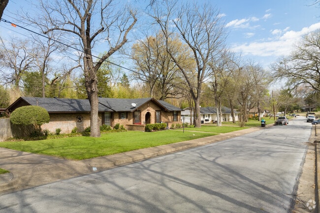 Contemporary ranch-style homes sit beneath large, mature trees in DeSoto.