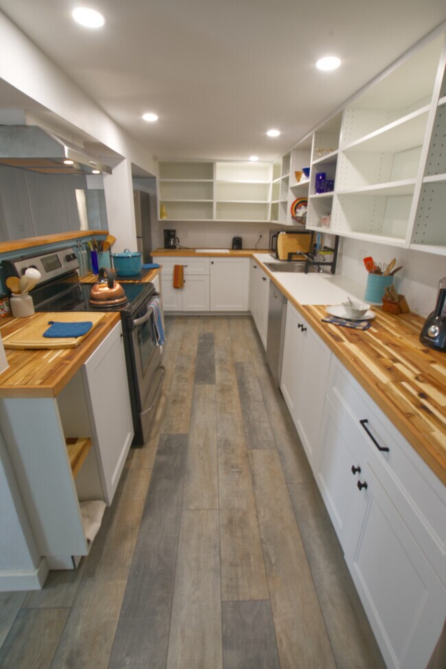 Kitchen counters are oiled butcher block and there's lots of open shelving for your pantry and perso