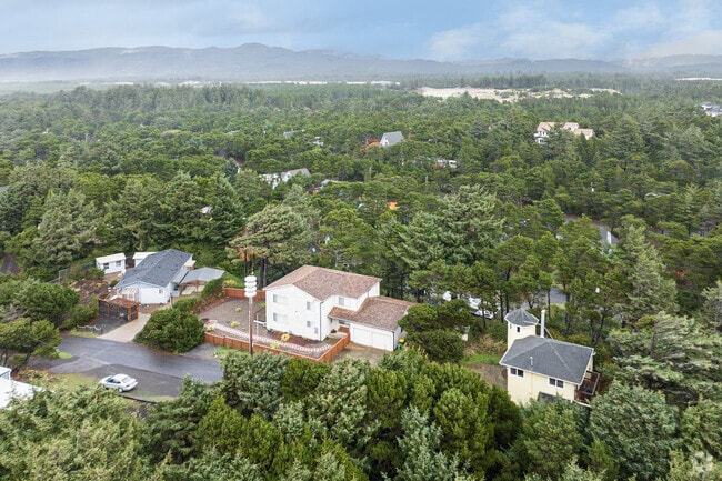 Wooded residential areas rest against a picturesque mountain backdrop in Heceta Beach.