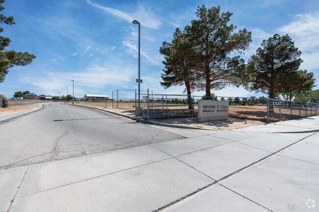 The Gifford C. Cole Middle School has an entrance sign that leads to the fenced in school.
