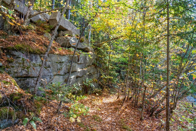 A trail passes by large stacks of granite stones milled from the quarries in East Barre.