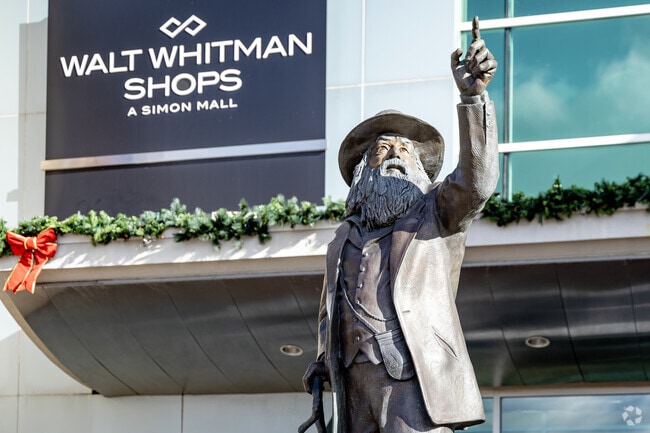 The statue of Walt Whitman welcomes shoppers to the shopping center in South Huntington that also bears his name.
