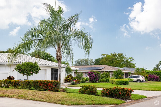 Hibiscus Country Club homes have neatly manicured lawns and tropical landscaping.