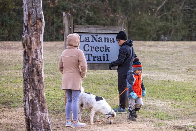 A family enjoys a walk along the LaNana Creek Trail at the Pecan Acres Park in Nacogdoches.