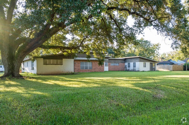 An updated ranch-style home sits beneath a mature oak tree in Jones Creek, Texas.