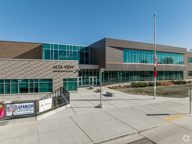 Alta View Elementary School is made of different colored gray bricks and large windows.