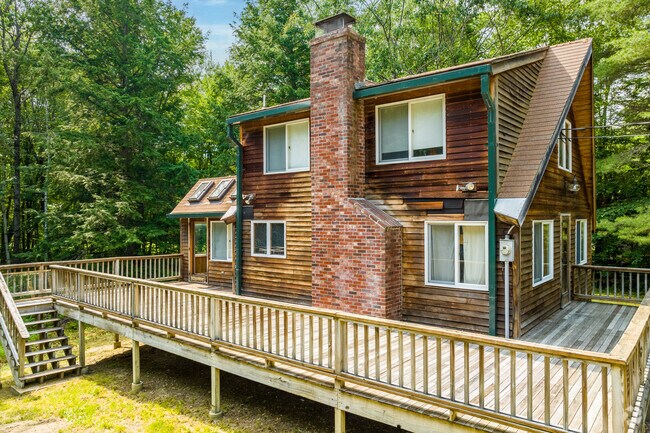 A wood sided home with a wrap around deck in Bridgton.