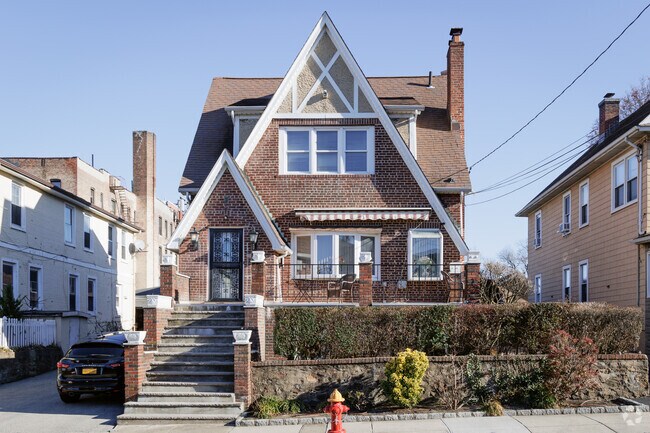 A stately Tudor style house shares a block with multi-family housing in Tibbets Hills.