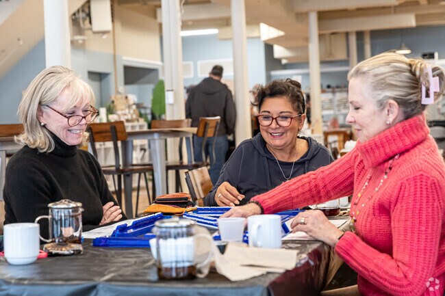 A group of friends enjoy coffee at The Firestone in Manchester while playing a game.
