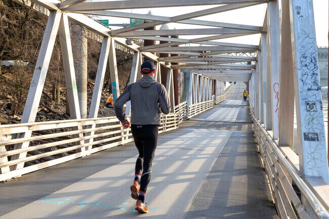 Runner is taking the bridge on the Eastbank Esplanade.