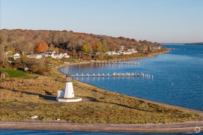 From Prudence Island Lighthouse looking north, the homes hug the shore and some have docks.