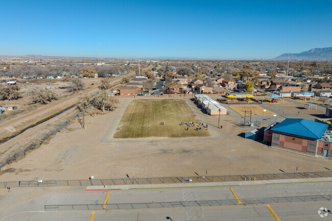 Large grass field and children at play at Pajarito Elementary School.