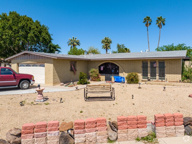 A nice adobe brick styled home with a rock garden