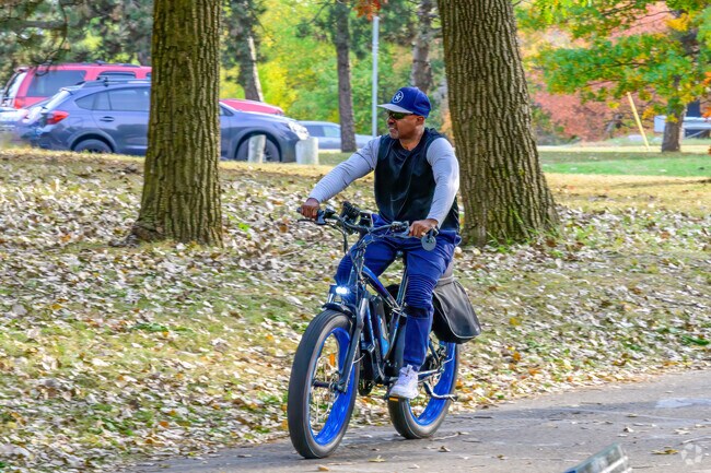 A man takes a leisurely bike ride on the Lansing River Trail near Knollwood Willow.