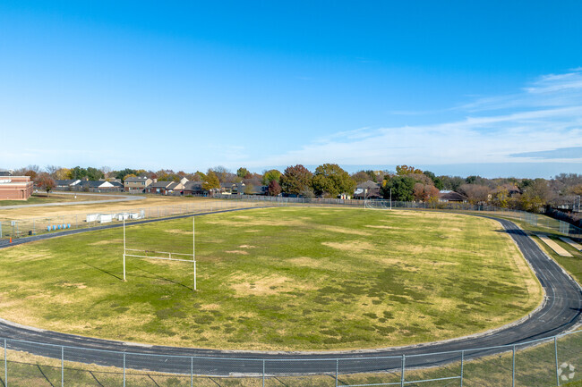 Lamar Middle School has a track surrounding an open green play area.
