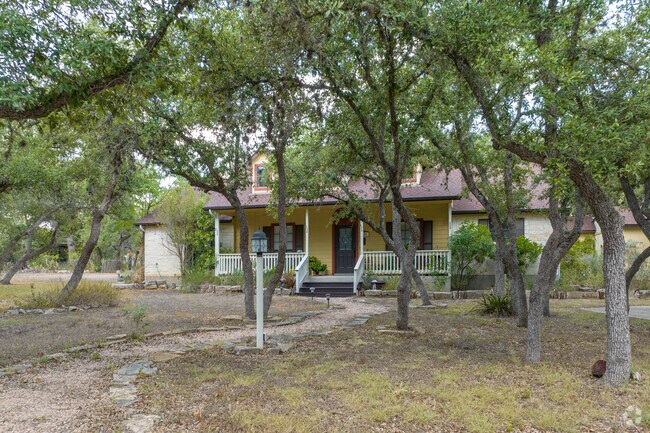 Charming two-story yellow house on a spacious rural lot in Wimberley Hills.