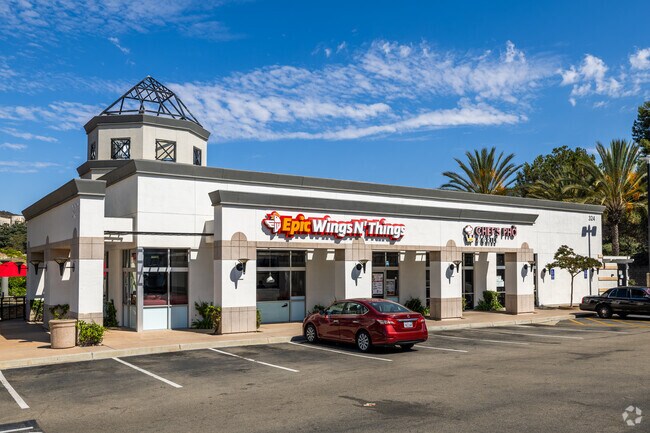 This part of the local strip mall has a Epic Wings and Pho restaurant in Village O San Marcos.