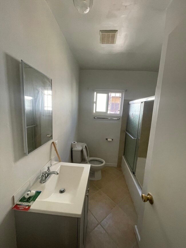 Bathroom with large new vanity and porcelain tile and bathtub - all new fixtures