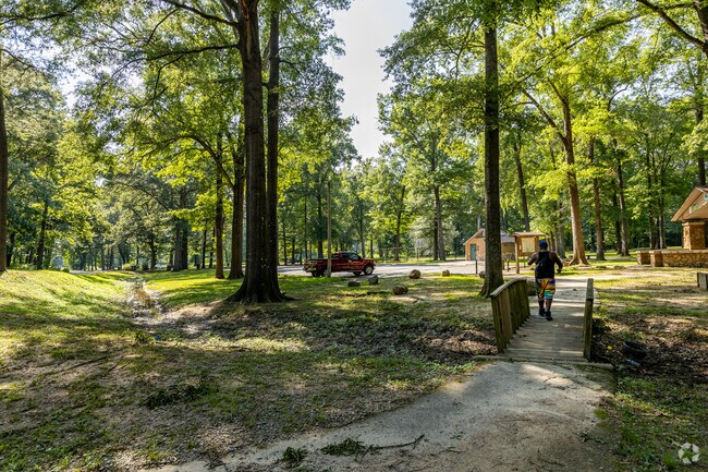 Residents walk under the trees of Pecan Lake to escape the bright sun.