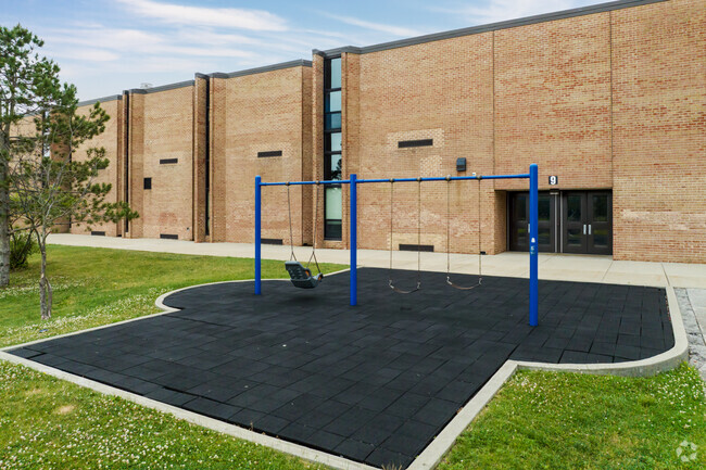 There is a swing set on the school's grounds.