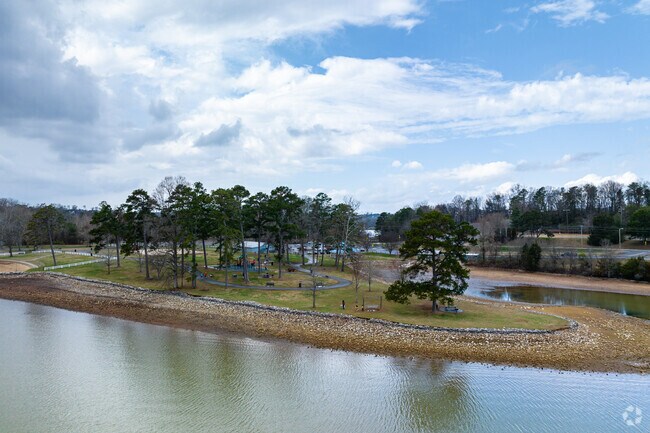 Trees line the walking path at The Cove at Concord Park, where water surrounds the tip.