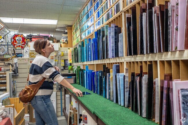 A Highland Place resident examines a colorful wall of stained glass at The Glass House store.