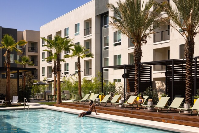 Pool deck with cabanas, waterfall spa, and fireplace seating