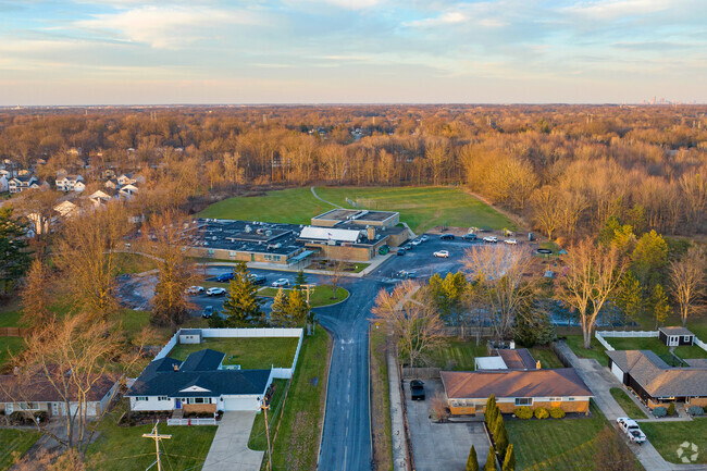Aerial view of Whitney Elementary School with Autumn foliage in the background.
