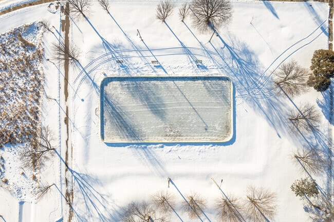 Families enjoy the maintained outdoor ice rink at Renstone Park in the winter season.