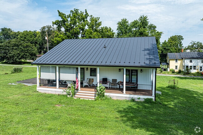 This single-story farmhouse in Boyce features a metal roof, front porch seating, and views of Clarke County’s countryside.