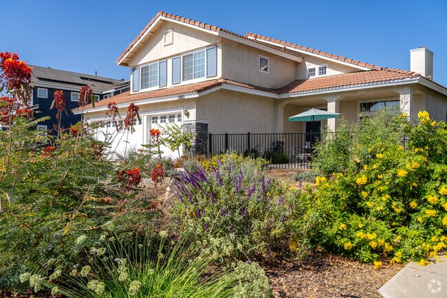 Vibrant landscaping surrounds this multi-story home, adding to the allure of Crystal Ranch.