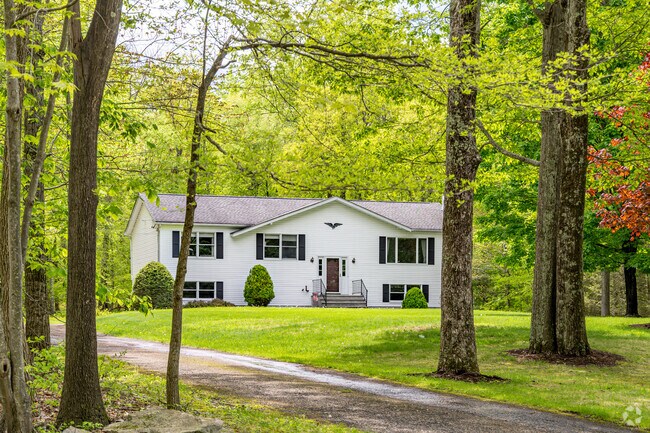 A stately residence nestled deep within the woods where long drives lead to open lawns and homes are tucked between shade and solitude.