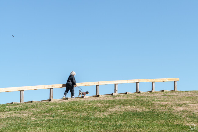 A local resident and her two-legged friend make their way to the top of the Mount Laurel veterans Memorial in Laurel Acres Park.