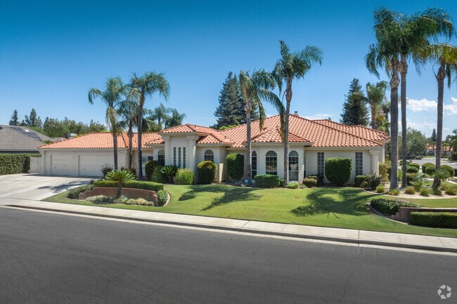 Spanish-style inspired home features large palm trees in the front yard in Haggin Oaks.