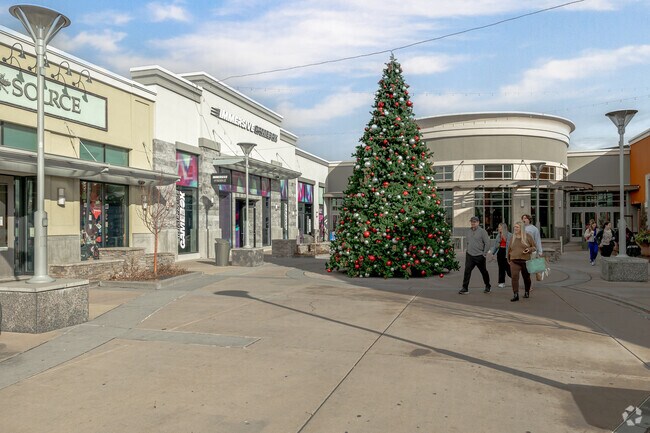A family walks by a large Christmas tree at Fashion Place in Murray.