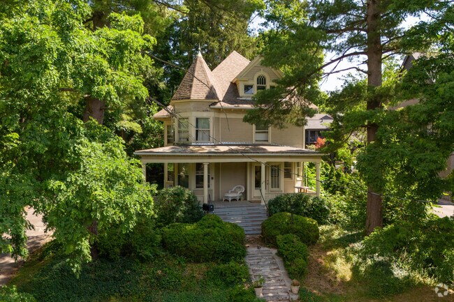 This Queen Anne home in Cornell Heights is set on a hill with plenty of old trees around it.