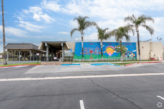 Cultural murals are depicted on multiple commercial buildings.