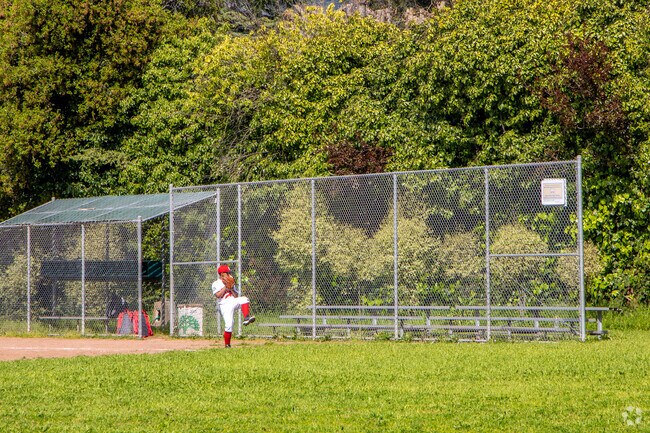 A young resident is practicing for a baseball game in the Central Reservoir Park in Oakland.
