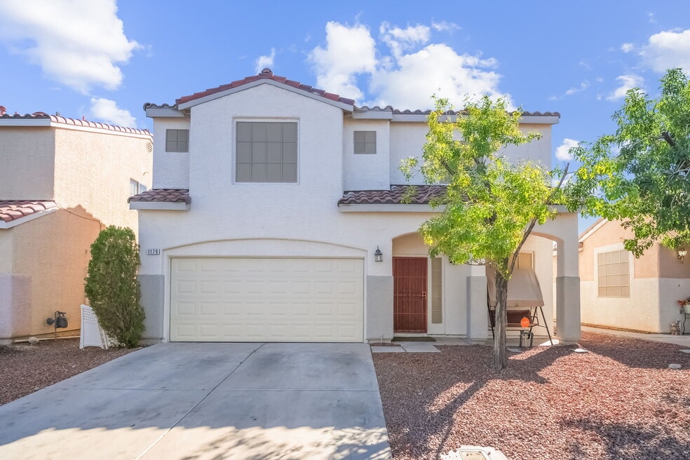 Mediterranean / spanish house featuring a tiled roof, concrete driveway, stucco siding, and a garage
