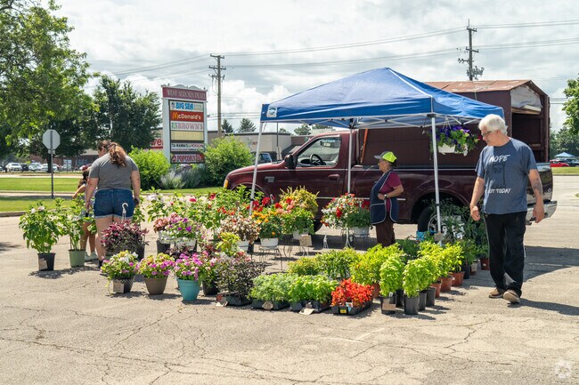 A mother and daughter look through flowers and plants at the Aurora Farmers Market.